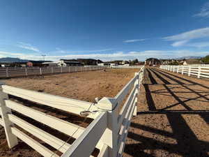 View of yard with an enclosed riding area, a residential view, and a mountain view