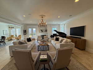 Living area featuring a chandelier, recessed lighting, and ornamental molding