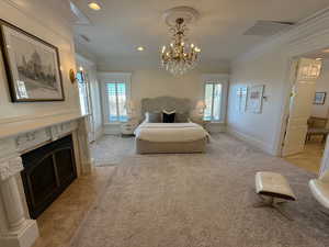 Bedroom featuring multiple windows, ornamental molding, a premium fireplace, a chandelier, and recessed lighting