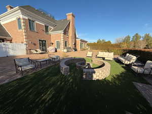 View of yard with an outdoor living space with a fire pit, a patio, and french doors