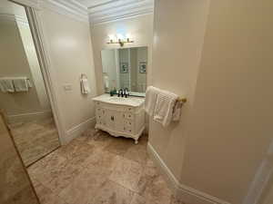 Bathroom featuring crown molding, vanity, a chandelier, and tile patterned floors