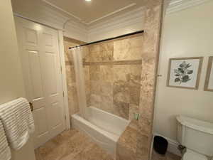 Bathroom featuring ornamental molding and shower / tub combo