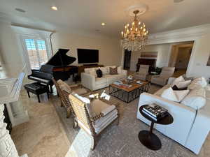 Living room featuring ornamental molding and a chandelier