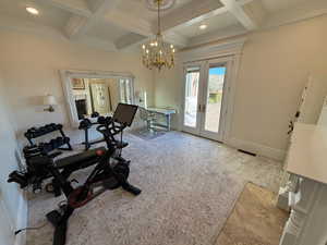 Workout room featuring french doors, coffered ceiling, ornamental molding, a chandelier, and carpet