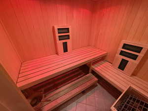 Sauna featuring tile patterned floors and wooden walls