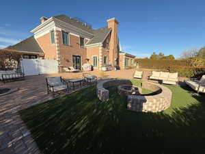 Back of property featuring a chimney, an outdoor living space with a fire pit, a patio, and french doors