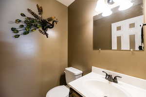 Half bath featuring toilet and vanity