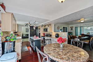 Dining space with dark wood-style floors, a textured ceiling, crown molding, and rail lighting