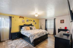 Bedroom featuring a textured ceiling and light wood-style floors