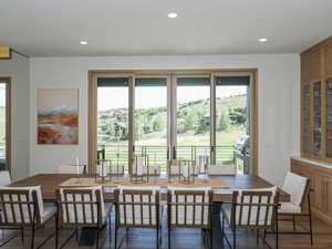 Dining area with plenty of natural light, wood finished floors, and recessed lighting