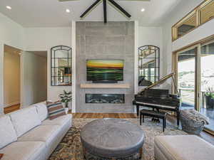 Living area with a fireplace, recessed lighting, wood finished floors, and a ceiling fan