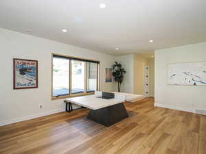 Office space featuring light wood finished floors and recessed lighting