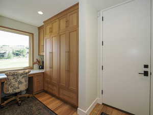 Office with light wood-type flooring, recessed lighting, and built in desk