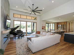 Living area with recessed lighting, wood finished floors, and a tiled fireplace