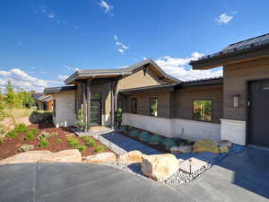 View of front of house featuring stone siding and a metal roof