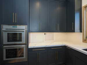Kitchen with double oven and light stone countertops