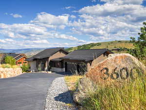 View of front of home with a garage, driveway, a metal roof, and a mountain view
