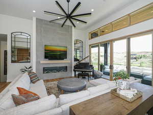 Living room with a fireplace, wood finished floors, and recessed lighting