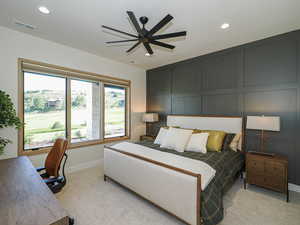 Bedroom featuring a decorative wall, recessed lighting, light colored carpet, and ceiling fan