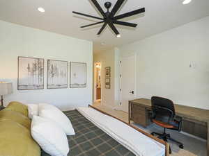 Carpeted bedroom featuring recessed lighting, a desk, and a ceiling fan
