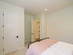Bedroom with light colored carpet and recessed lighting
