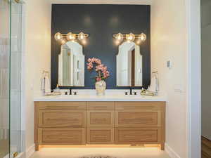 Full bath featuring double vanity and an enclosed shower