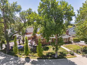 View of property hidden behind natural elements with a fenced front yard