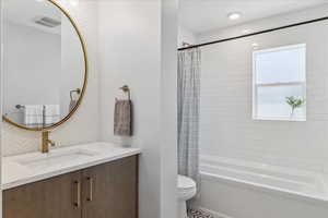 Full bathroom featuring vanity and shower / bathtub combination with curtain