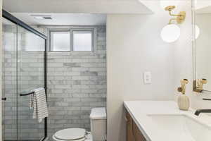 Bathroom featuring vanity and a shower stall