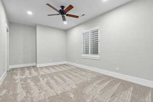 Carpeted spare room featuring a ceiling fan and recessed lighting