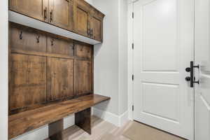 Mudroom featuring light wood-style floors and baseboards