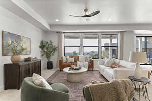 Living room featuring light carpet, ceiling fan, and recessed lighting