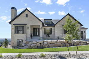 View of front facade with stone siding and a chimney