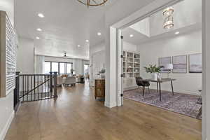 Corridor with recessed lighting, wood finished floors, an office area, an upstairs landing, and crown molding