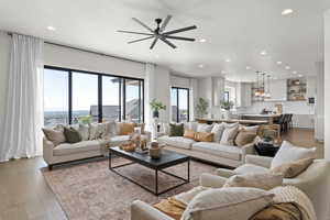 Living area featuring light wood-type flooring, recessed lighting, and a ceiling fan