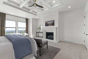 Bedroom with coffered ceiling, recessed lighting, beamed ceiling, light colored carpet, and a fireplace