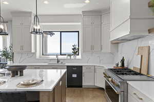 Kitchen featuring high end stove, dishwasher, recessed lighting, light wood-style floors, and decorative backsplash