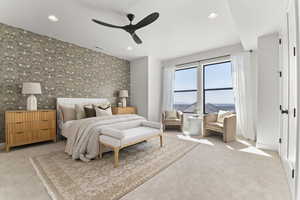 Bedroom with wallpapered walls, light colored carpet, an accent wall, recessed lighting, and ceiling fan