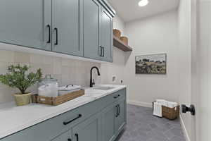 Laundry room with electric dryer hookup, hookup for a washing machine, cabinet space, and dark tile patterned floors