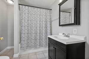 Full bath with vanity, tile patterned flooring, and shower / bathtub combination with curtain