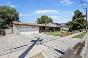 Traditional home with a garage, concrete driveway, a shingled roof, covered porch, and brick siding