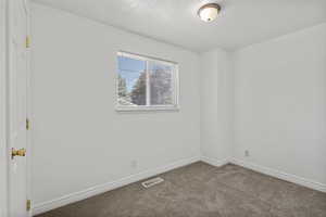 Carpeted empty room featuring baseboards