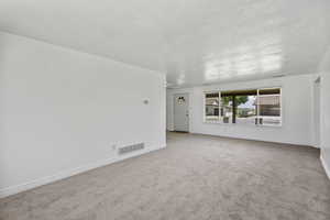 Carpeted spare room with baseboards