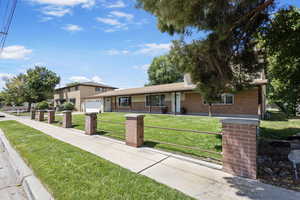 View of front of property with brick siding and a front yard