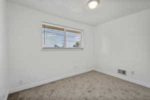Empty room with carpet floors and baseboards