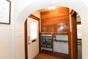 Foyer entrance featuring arched walkways, wood finished floors, and baseboard heating