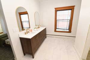 Ensuite bathroom with a sink and a baseboard radiator