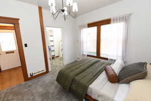 Bedroom with a spacious closet, a chandelier, and carpet flooring