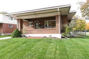 View of front of property featuring covered porch and brick siding