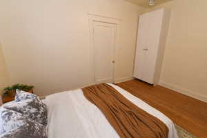 Bedroom with wood finished floors and baseboards